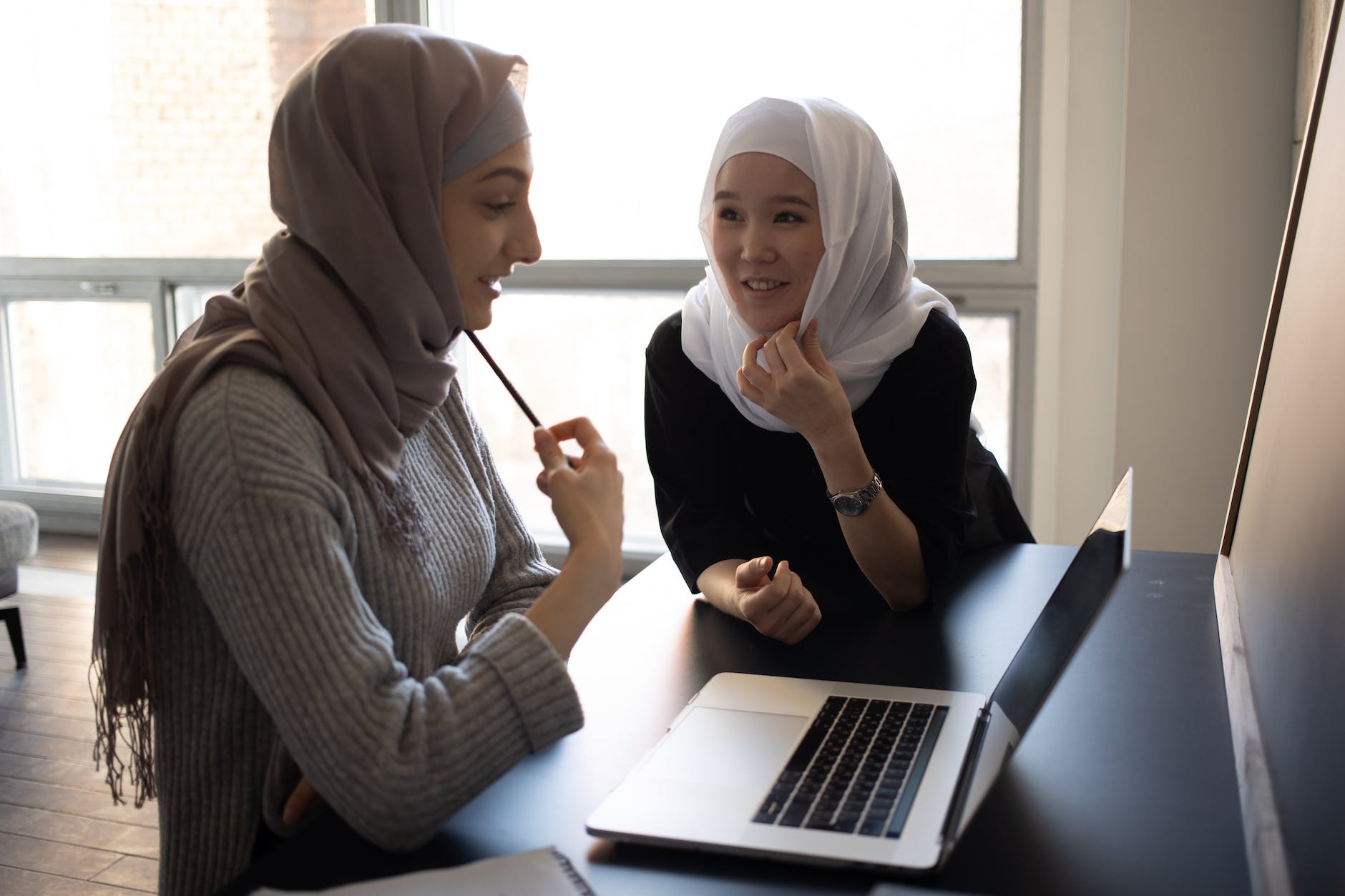 homeworksmontana. content multiracial women in hijabs browsing laptop in classroom